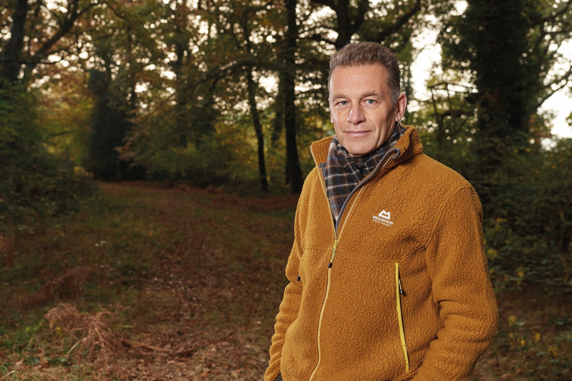 Credit: Alamy Chris Packham stands in the woods wearing a fleece jacket and scarf