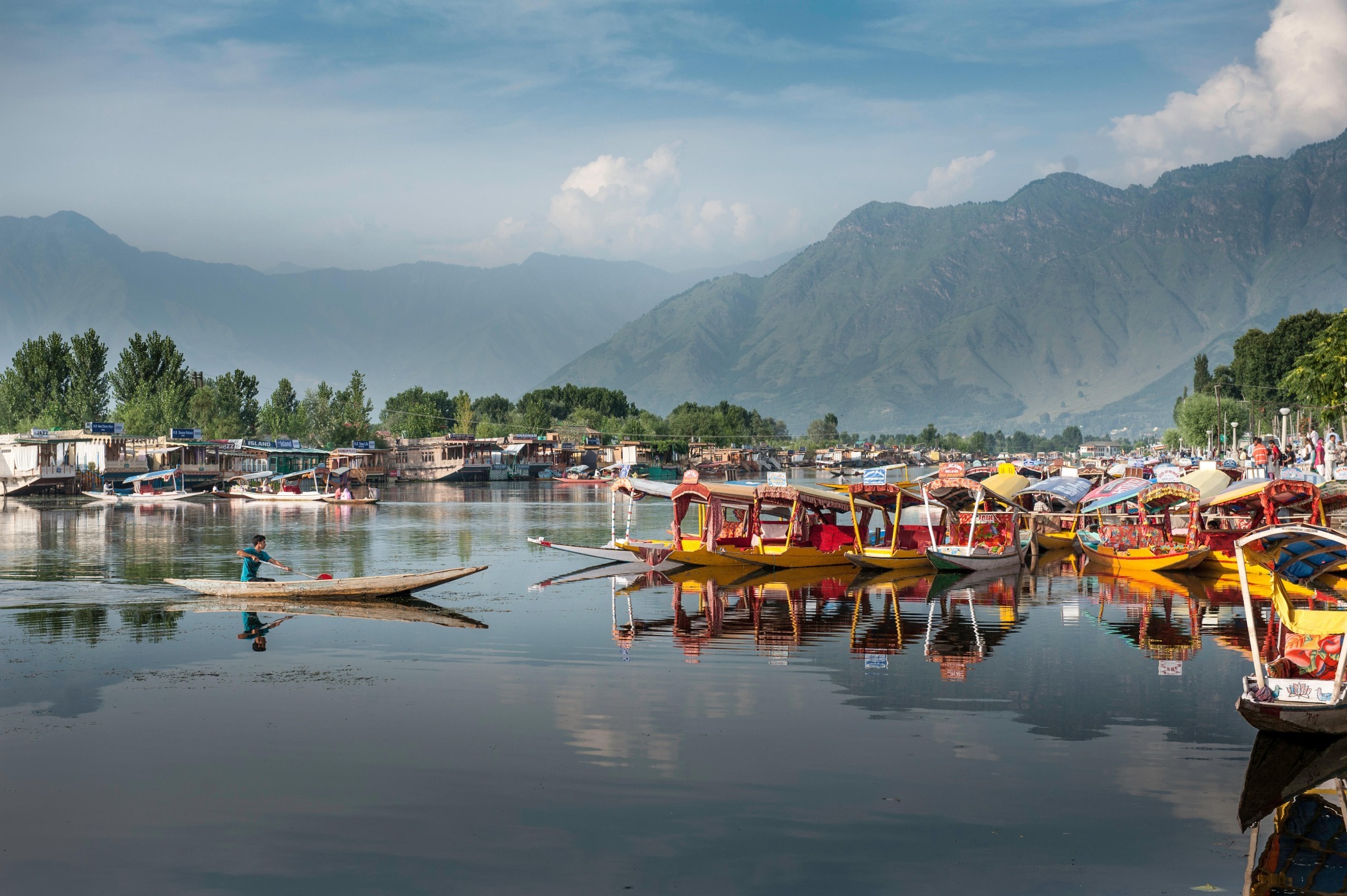 Dal Lake in Srinagar. Credit: Alamy Yellow boats on Dal Lake in Srinagar, with mountains in the background