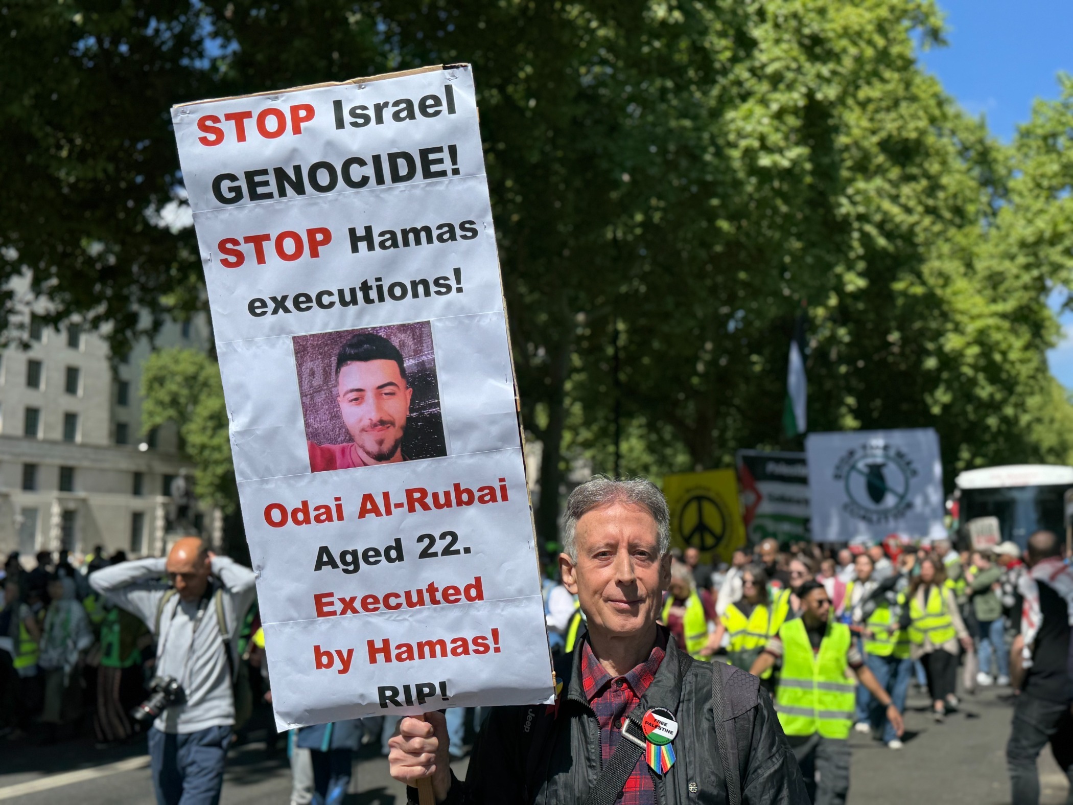 Peter Tatchell at a Palestine solidarity protest carrying a sign that reads: 'Stop Israel genocide! Stop Hamas executions!'