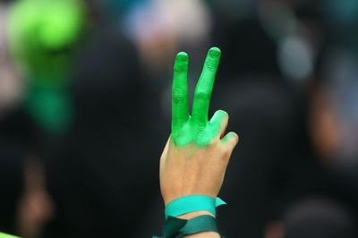An Iranian with green painted fingers protests against the government