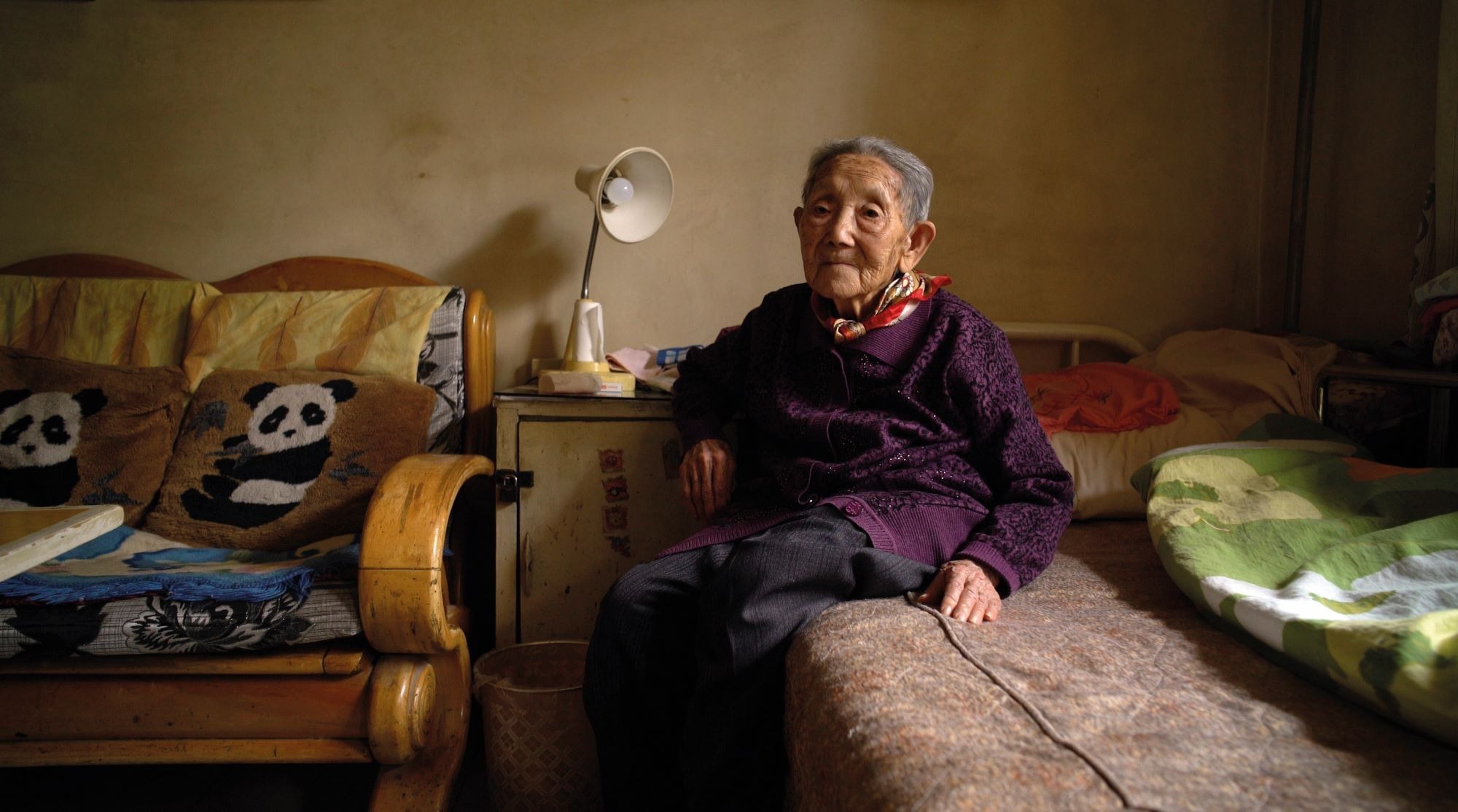 A portrait of an elderly Chinese woman in her bedroom - a scene from Wang Bing's documentary 'Dead Souls'