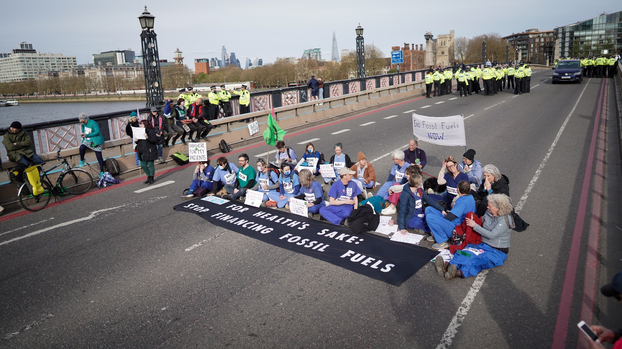 A group of medical professionals block Lambeth Bridge in London to protest against fossil fuel extraction