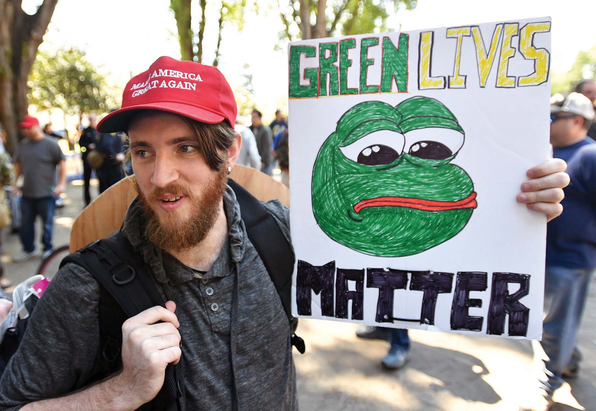 A protester holds a sign depicting Pepe the Frog, a popular a symbol within the alt-right, at a rally in California Alt-right