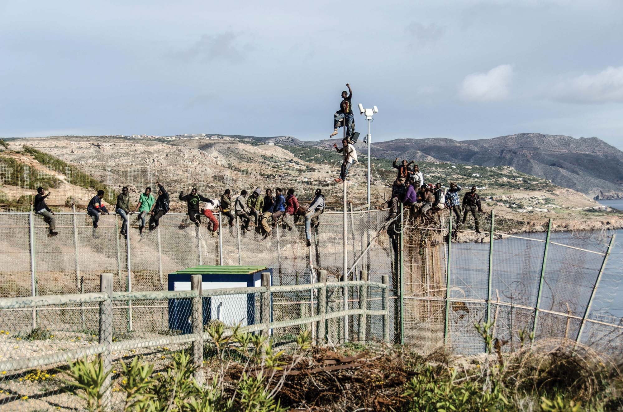 People scale border fences at one of Spain’s territorial enclaves in North Africa People scale border fences at one of Spain’s territorial enclaves in North Africa