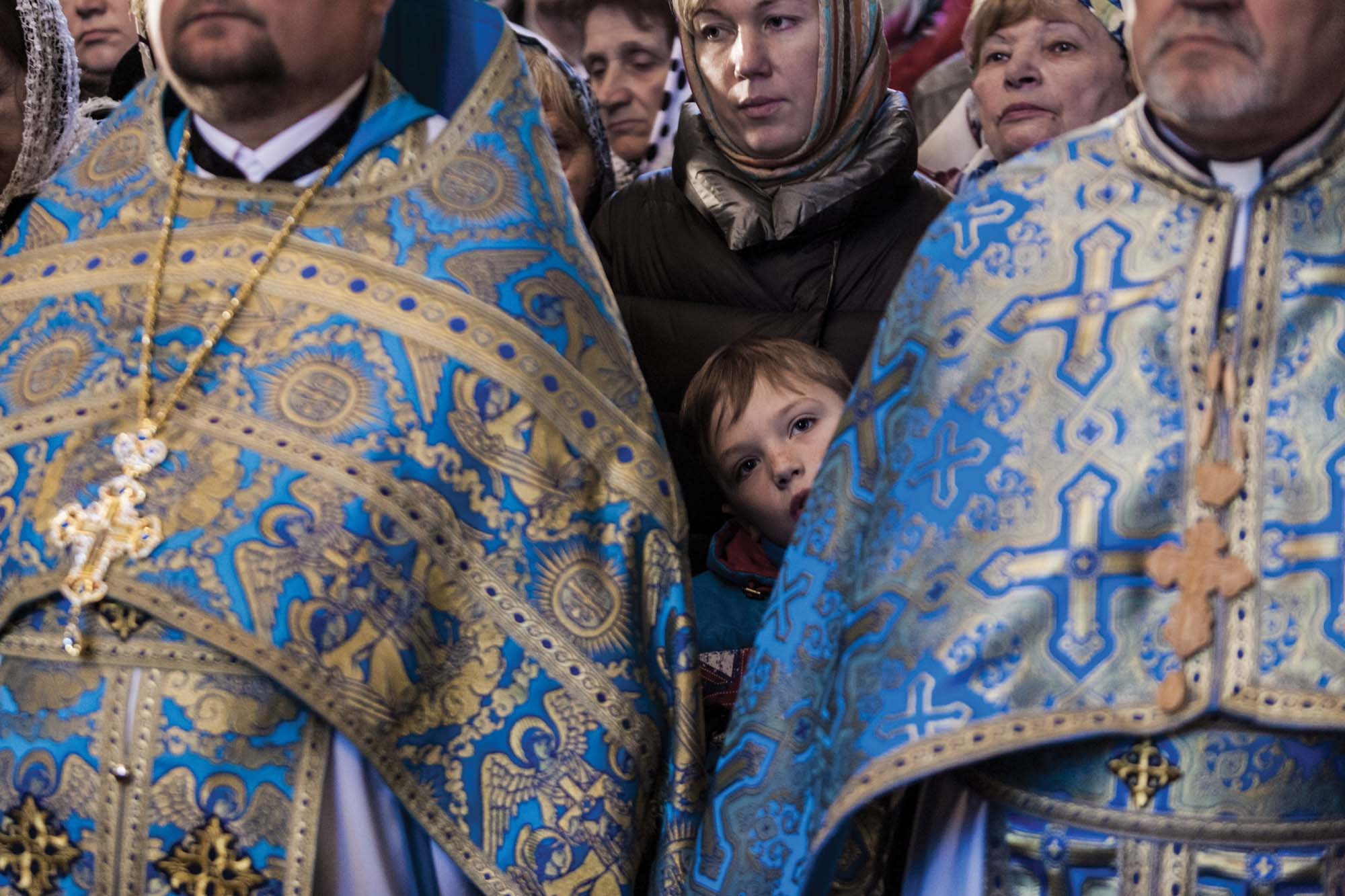 A child listens to mass, delivered by the head of the Orthodox Church of Ukraine in Rivne, April 2019 Ukraine Church